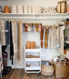 an organized closet with lots of hanging items and baskets on the shelves, along with other things