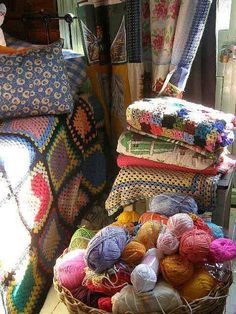 a basket filled with balls of yarn next to a bed