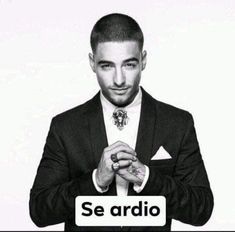 a black and white photo of a man in a suit holding his hands together with the words se ardio on it