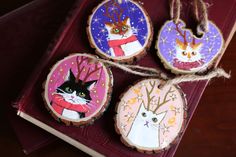 four decorated wooden ornaments with cats on them