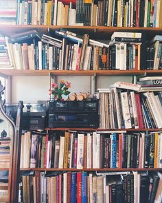 a bookshelf filled with lots of books next to a wall full of books