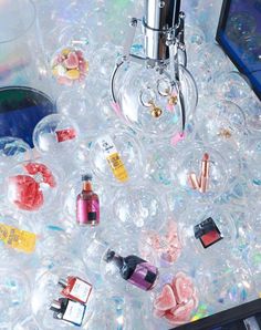 an assortment of bottles and other items on top of bubble filled plastic balls with water in the background