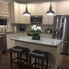 a kitchen with two stools and a center island