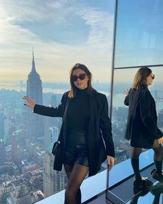 a woman standing on top of a tall building