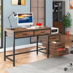 a computer desk with a monitor, keyboard and mouse in front of a brick wall