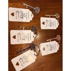 six key tags with the names of four different keys in them on a wooden table