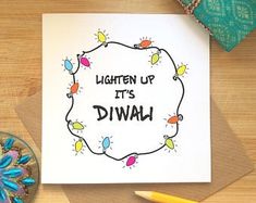 a card with the words, lighten up its diwal on it next to a bowl of pencils