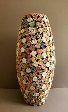 a large vase made out of many different bottle caps