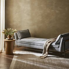 a living room with a couch, table and chair next to a wall painted in brown