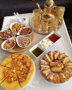 a table topped with lots of desserts and plates filled with different types of food