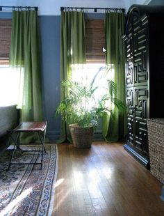 a living room filled with furniture and green curtains