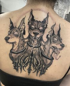 the back of a woman's neck with tattoos on it and two deers