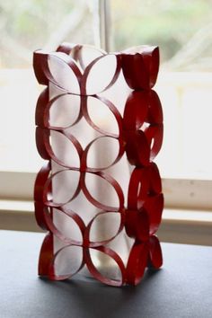 a red and white vase sitting on top of a table