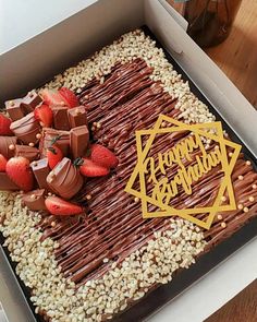 a birthday cake in a box with strawberries and chocolate