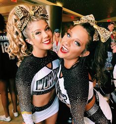 two cheerleaders are posing for the camera