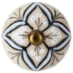 a white and black flower knob with gold center