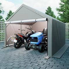 two motorcycles are parked in front of a garage with a tent on the roof and one motorcycle is parked next to it