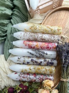 a bunch of candles sitting on top of a wooden table next to flowers and other items