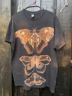 a t - shirt with moths painted on it