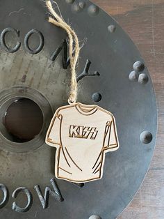 a wooden ornament hanging from the side of a metal object with words on it