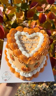 a heart shaped cake is being held by someone