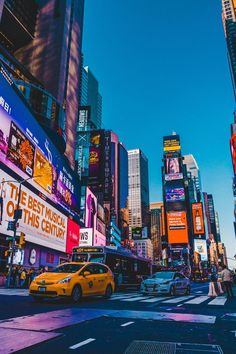 a city street filled with lots of tall buildings and neon signs on the side of it