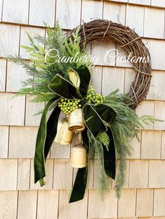 a wreath with bells and greenery hangs on a wall