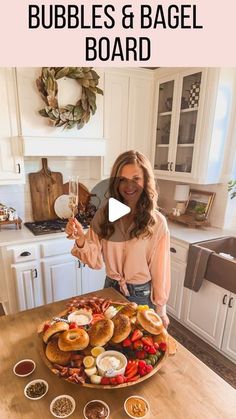 a woman standing in front of a table with food on it and the words bubbles & bagel board