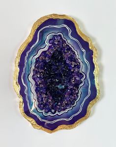 a purple and gold plate on a white surface