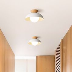 three lights are hanging from the ceiling in a hallway with wood paneling and white walls