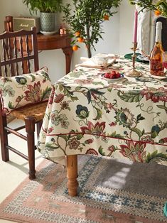 a dining room table covered with a flowered tablecloth