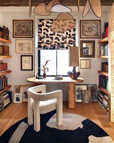 a room filled with lots of books and furniture next to a window covered in animal prints