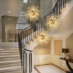 an elegant staircase with chandeliers and lamps