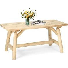 a wooden table with flowers on it and an open book next to it, against a white background