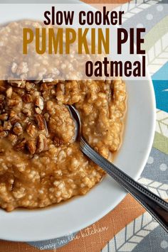 a bowl of oatmeal with pecans on top and spoon in it