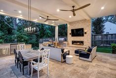 an outdoor kitchen and dining area with ceiling fans