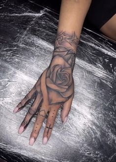 a woman's hand with a rose tattoo on the middle of her left arm