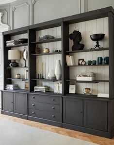 a living room filled with lots of furniture and books on top of wooden bookcases