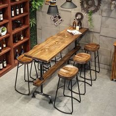 a wooden table with four stools in front of it and bottles on the shelves