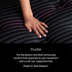 a woman's hand resting on top of a black and purple striped bed spread