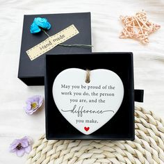 a heart shaped ornament in a black box with a message on the inside