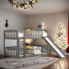 there is a bunk bed with a slide in the middle and a christmas tree on the other side