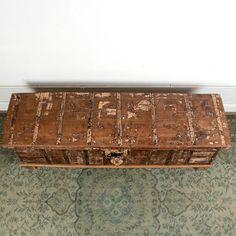 an old wooden trunk sitting on top of a rug