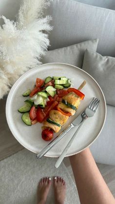 a white plate topped with food next to a person's legs