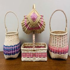 three woven baskets sitting on top of a wooden table