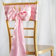 a pink chair sash sitting on top of a wooden chair