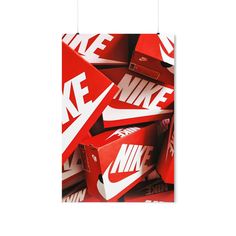 a pile of red and white nike signs hanging from the side of a wall in front of a white background