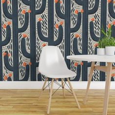 a table and chair in front of a wallpapered cactus pattern with orange flowers