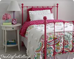 a bedroom with pink and white bedding, polka dot comforter on the pillow