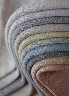 a pile of different colored blankets sitting on top of each other